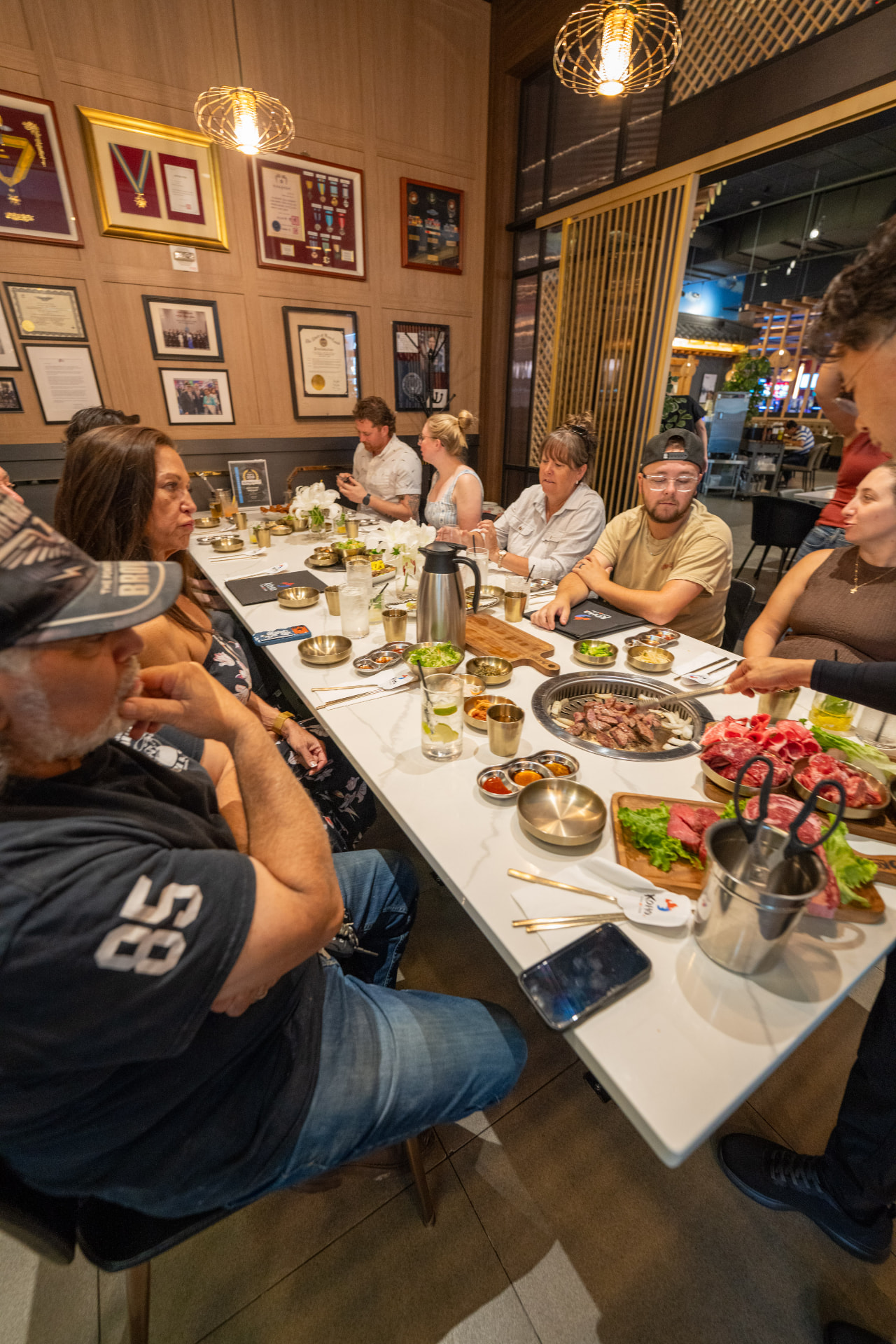 Guests sharing Korean BBQ around the long table in The Honor Room